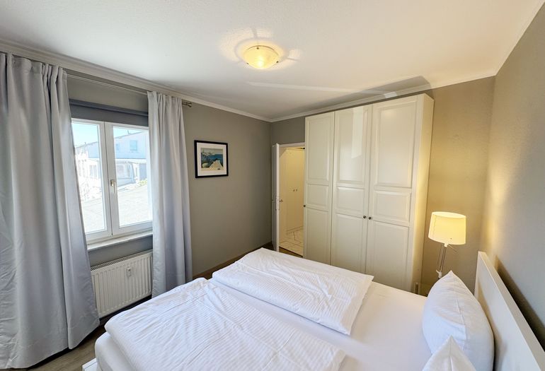 Schlafzimmer mit Doppelbett und Kleiderschrank
