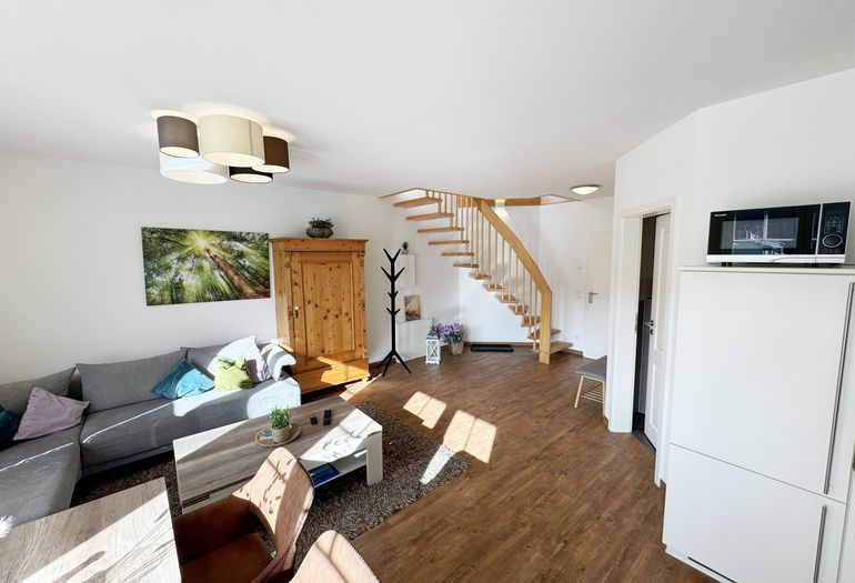 Wohnbereich mit Blick auf die Treppe zum Obergeschoss Wohnbereich mit Blick auf die Treppe zum Obergeschoss