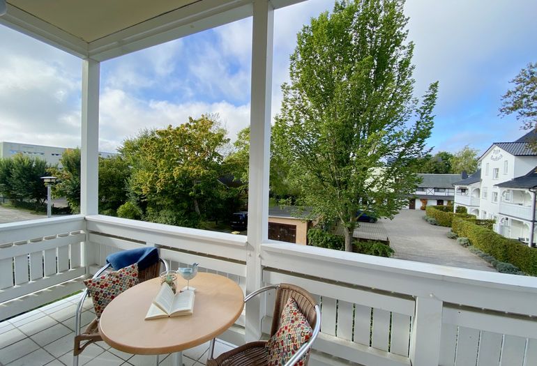 bestuhlter Balkon mit Blick zur Straße