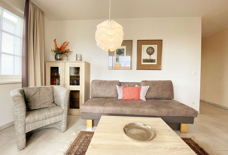 Wohnzimmer mit Couch und Sessel