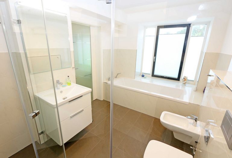 Badezimmer mit Badewanne und Dusche