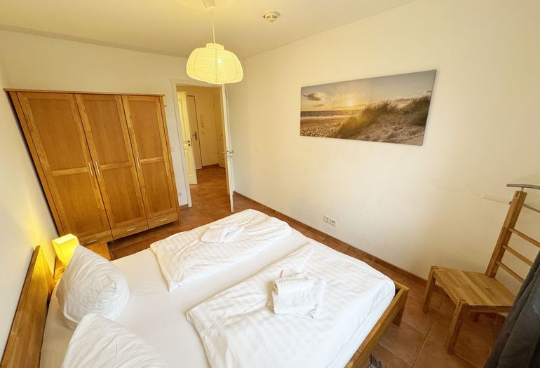 Schlafzimmer mit Doppelbett und Kleiderschrank