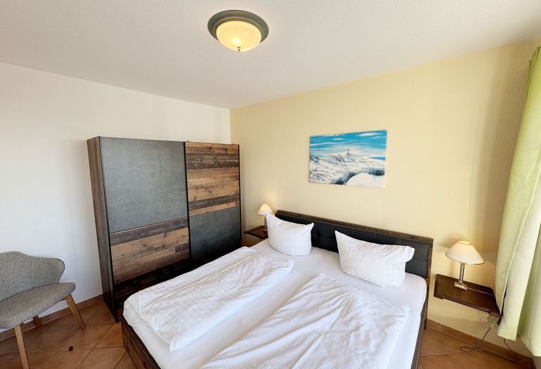 Schlafzimmer mit Doppelbett und Kleiderschrank