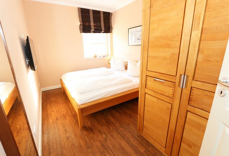 Schlafzimmer mit Doppelbett und Kleiderschrank