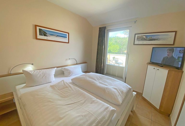 Schlafzimmer mit Doppelbett und Zugang zur Dachterrasse