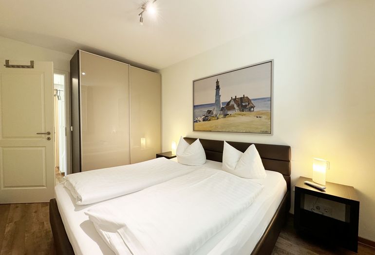 Schlafzimmer mit Doppelbett und Kleiderschrank