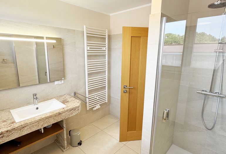 Badezimmer mit Waschbecken und Dusche