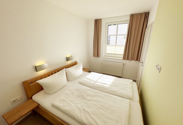 Schlafzimmer mit Doppelbett mit Nachttischkonsolen