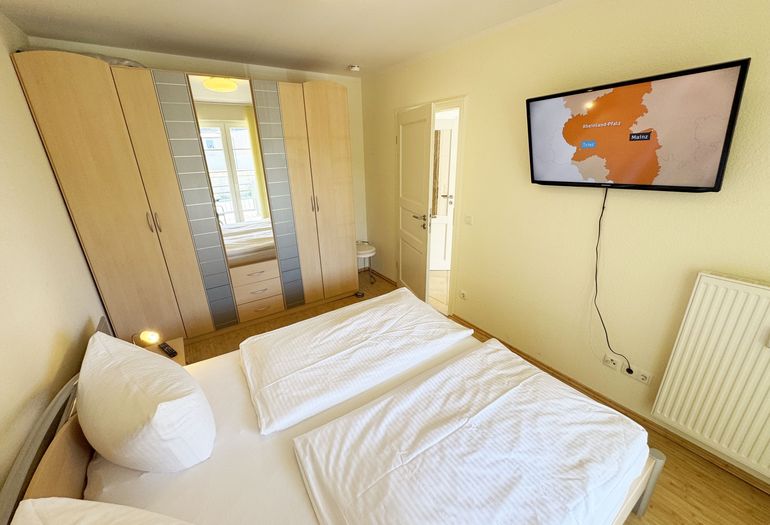 Schlafzimmer mit Doppelbett und Kleiderschrank