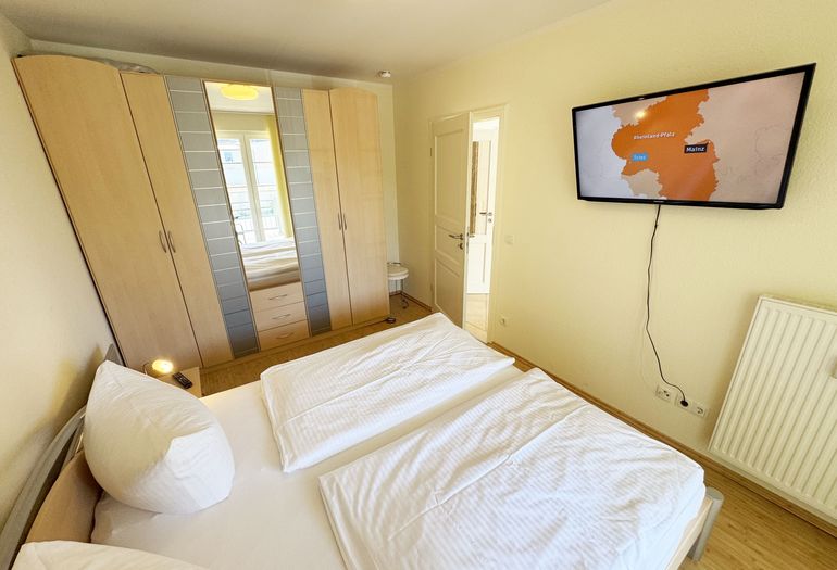 Schlafzimmer mit Doppelbett und Kleiderschrank