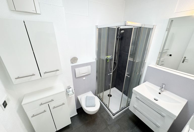 innenliegendes Bad mit Waschbecken, Dusche mit niedrigem Einstieg, WC, Kosmetikspiegel, Handtuchheizkörper innenliegendes Bad mit Waschbecken, Dusche mit niedrigem Einstieg, WC, Kosmetikspiegel, Handtuchheizkörper