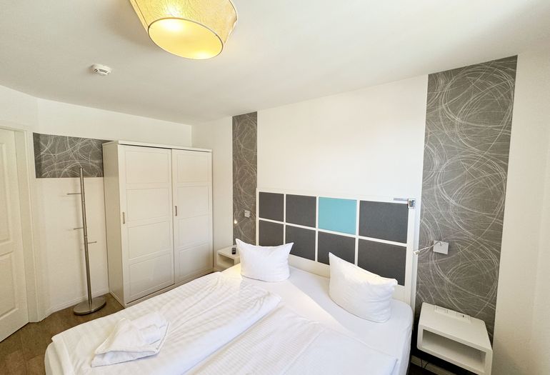 Schlafzimmer mit Doppelbett und Kleiderschrank