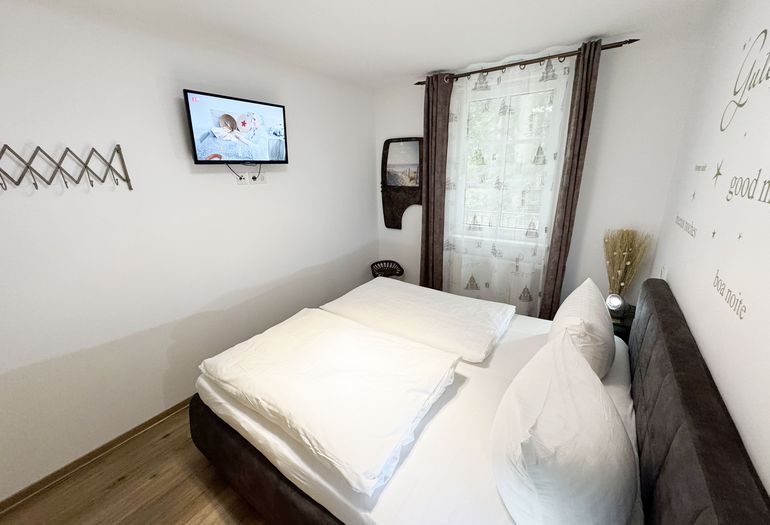 Schlafzimmer mit Doppelbett mit Flachbild-TV