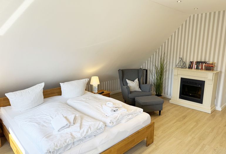 1. Schlafzimmer mit Doppelbett und Ohrensessel