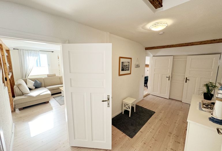 Flurbereich mit Zugang zu den Schlafräumen, Küche & Wohnraum