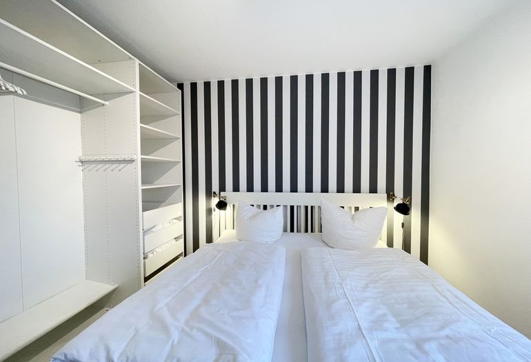 Schlafzimmer mit offenem Kleiderschrank