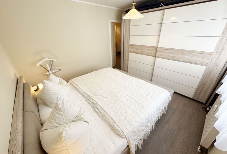 Schlafzimmer mit Doppelbett und Kleiderschrank