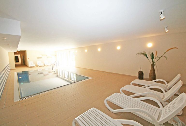 Wellnessbereich mit Liegen und Pool Wellnessbereich mit Liegen und Pool