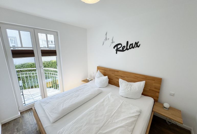 Schlafzimmer mit Doppelbett und Zugang auf den Balkon