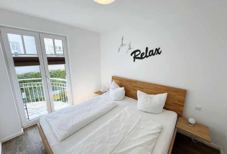 Schlafzimmer mit Doppelbett und Zugang auf den Balkon
