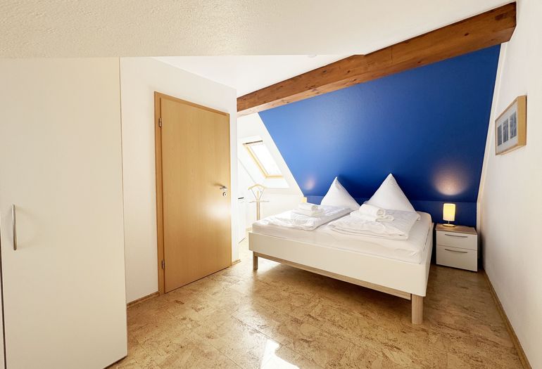 Schlafzimmer mit Doppelbett und Smart-TV