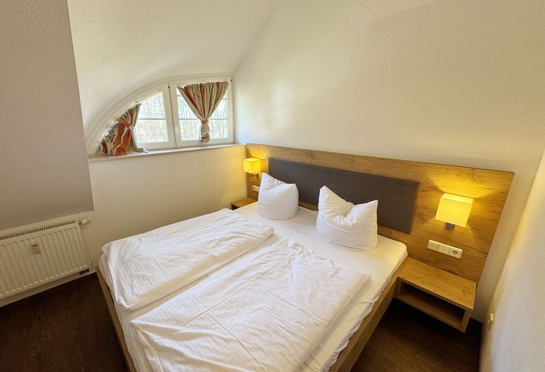 Schlafzimmer mit Doppelbett und Nachttischkonsolen