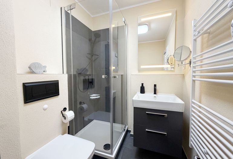 innenliegendes Bad mit Waschbecken, Dusche mit niedrigem Einstieg, WC, Kosmetikspiegel, Handtuchheizkörper