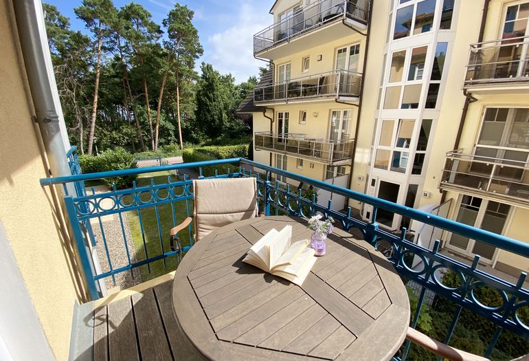 bestuhlter Balkon mit Blick zu den Kiefern