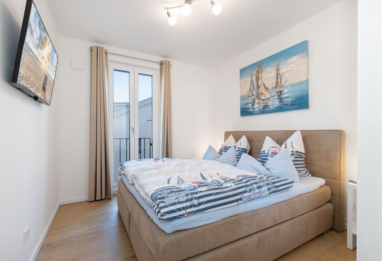 Schlafzimmer mit Doppelbett und Smart-TV