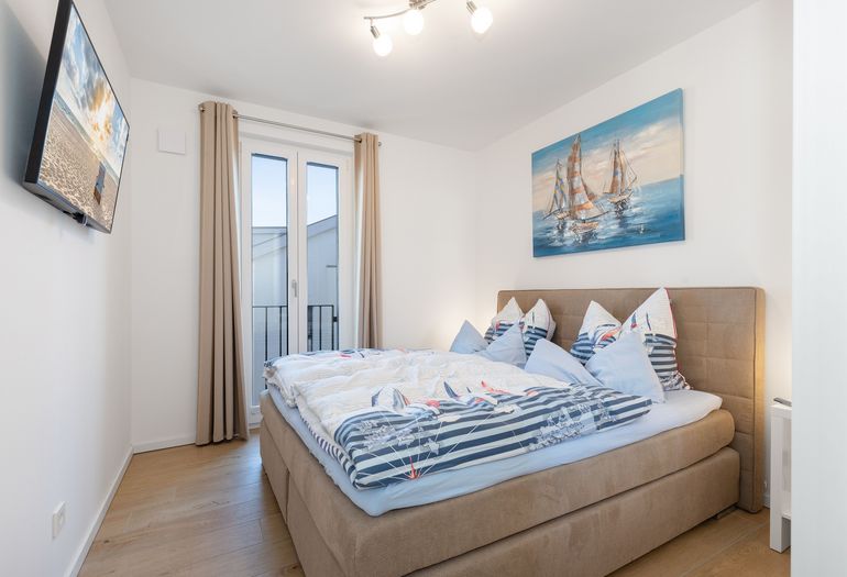 Schlafzimmer mit Doppelbett und Smart-TV