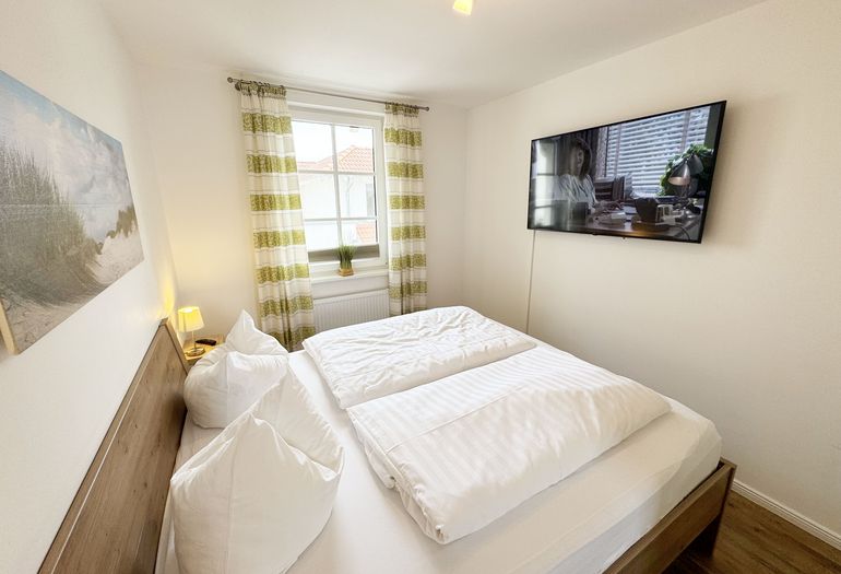 1. Schlafzimmer mit Doppelbett und Smart-TV
