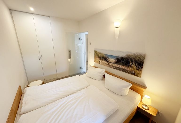 Schlafzimmer mit Doppelbett und Kleiderschrank