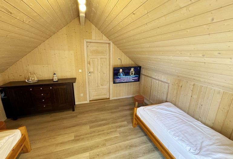 Ferienhaus Sprottenkiste - Schlafzimmer im Dachgeschoss mit TV