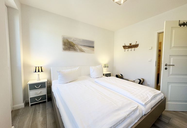 1. Schlafzimmer mit Doppelbett und Nachttischablagen 1. Schlafzimmer mit Doppelbett und Nachttischablagen