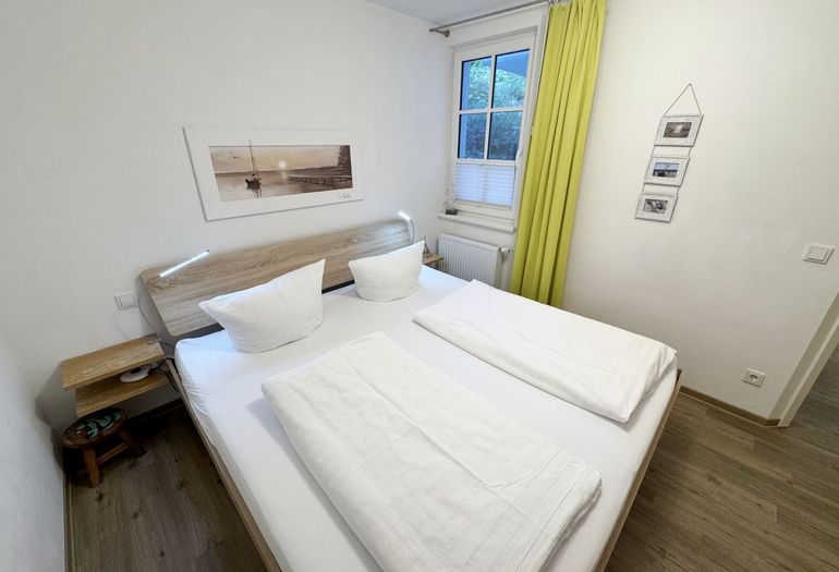 Schlafzimmer mit Doppelbett und Nachttischablagen