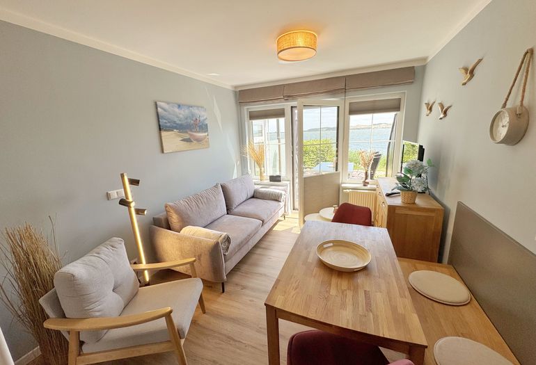 Wohnzimmer mit gemütlichem Essbereich und Seeblick