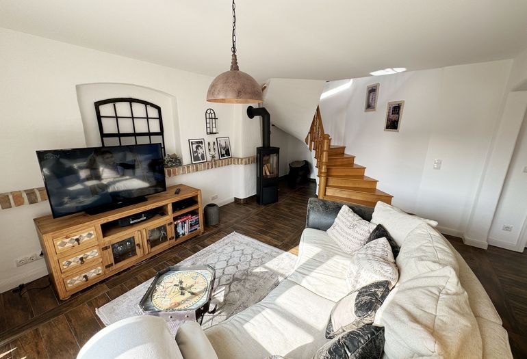 Wohnbereich mit großem Fernseher und Kamin