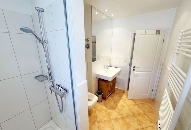 Badezimmer mit Dusche und Waschbecken