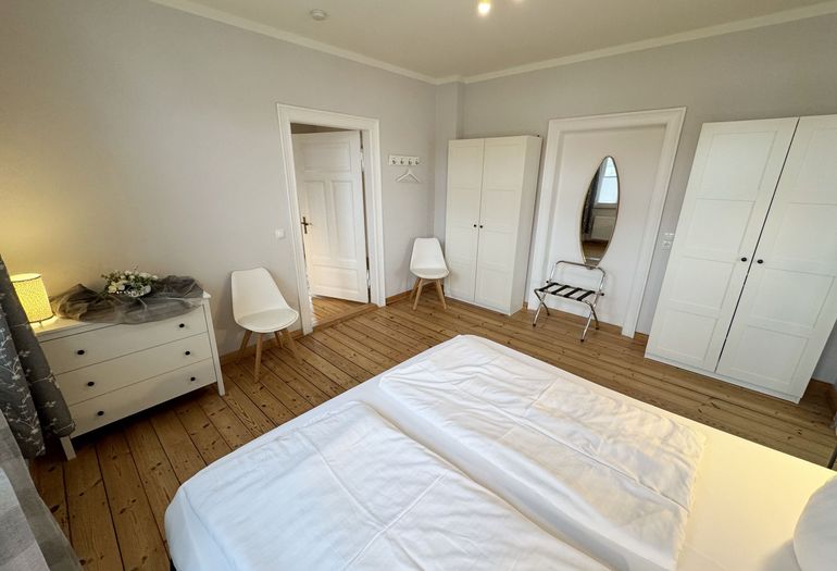 Schlafzimmer mit Doppelbett und Kleiderschrank