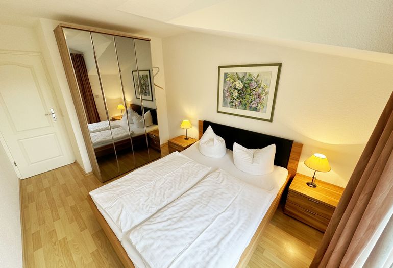 Schlafzimmer mit Doppelbett und Kleiderschrank