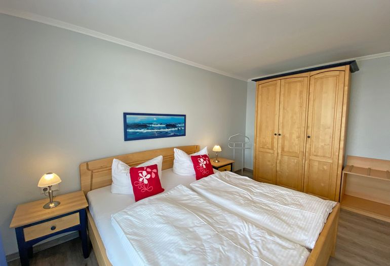 Schlafzimmer mit Doppelbett und Kleiderschrank