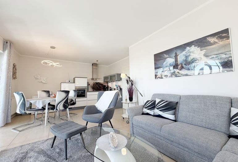 Wohnbereich mit Couch, Sessel, Couchtisch und Smart-TV Wohnbereich mit Couch, Sessel, Couchtisch und Smart-TV