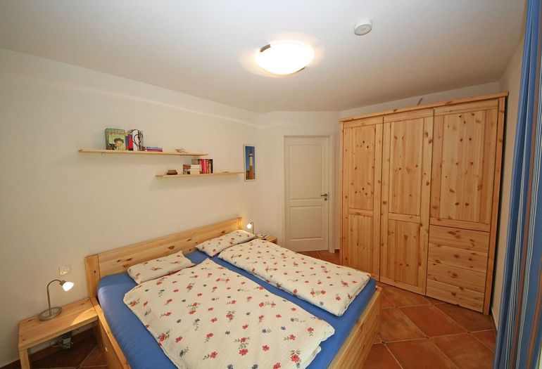 Schlafzimmer mit Doppelbett und Kleiderschrank