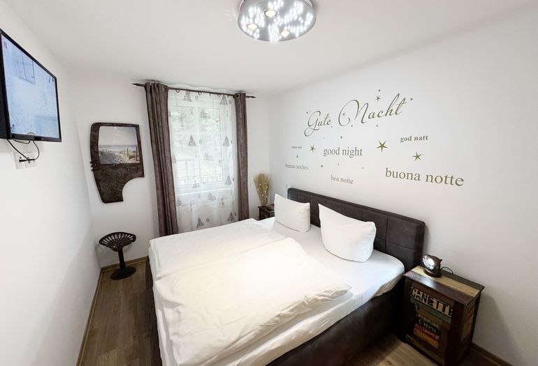 Schlafzimmer mit Doppelbett und Nachttischablagen