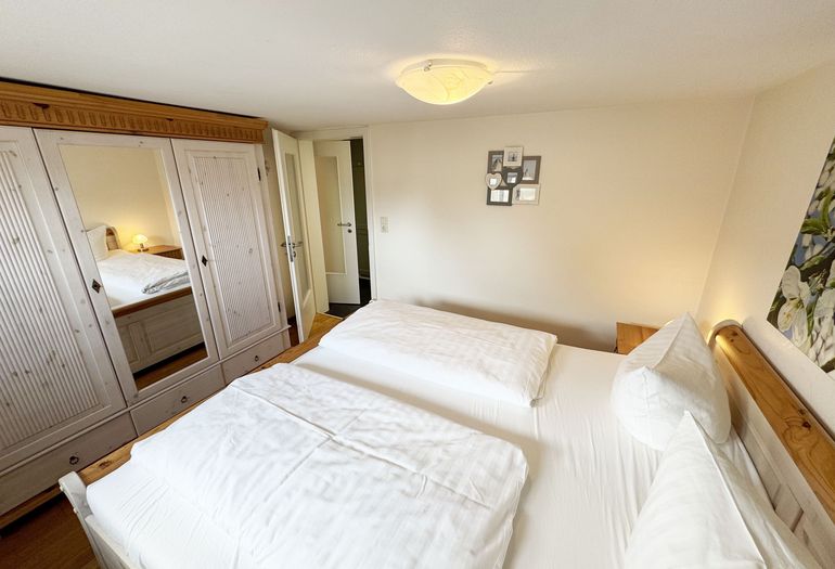 Schlafzimmer mit Doppelbett und Kleiderschrank