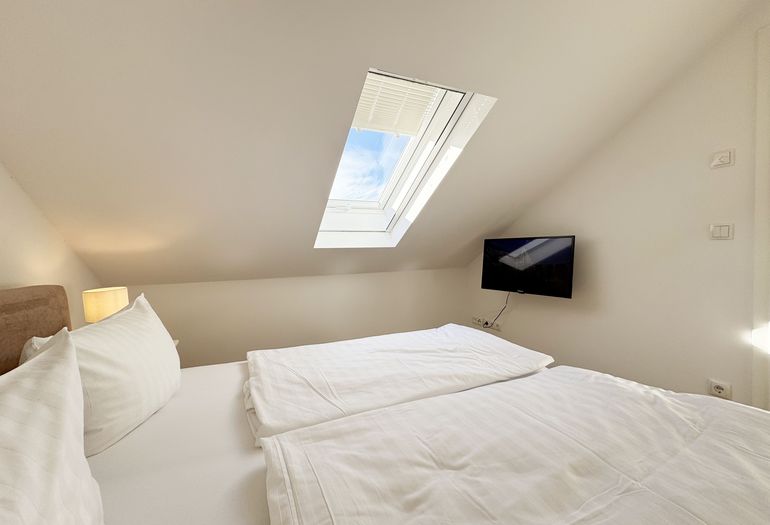 1. Schlafzimmer mit Doppelbett und TV