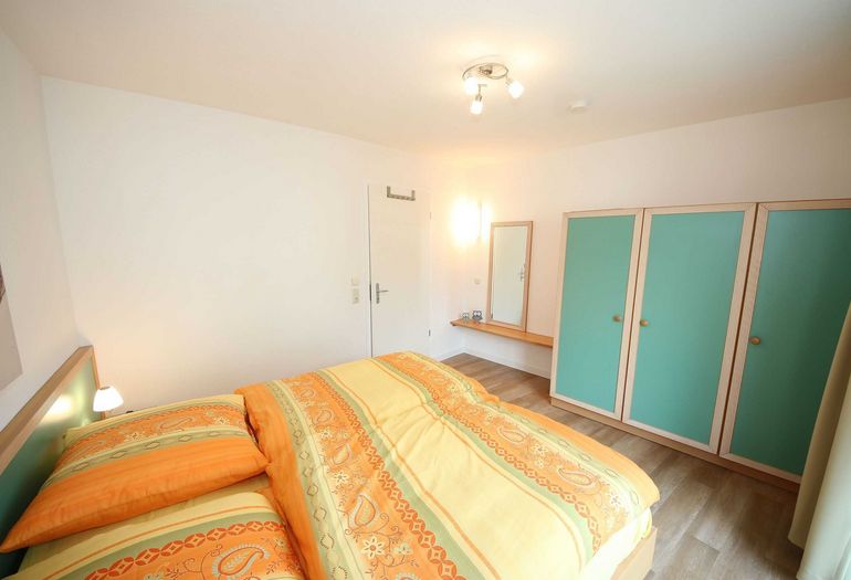 Schlafzimmer mit Doppelbett und Kleiderschrank