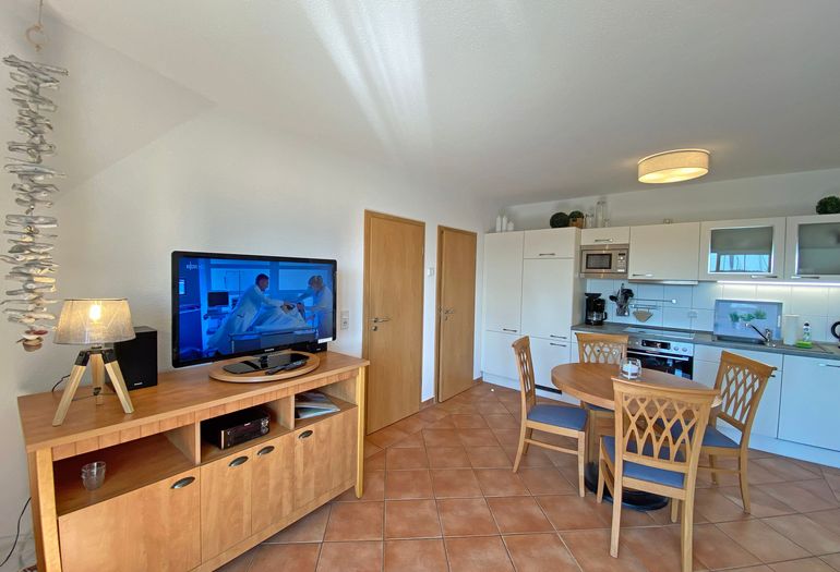 Wohnzimmer mit TV und Küchenzeile