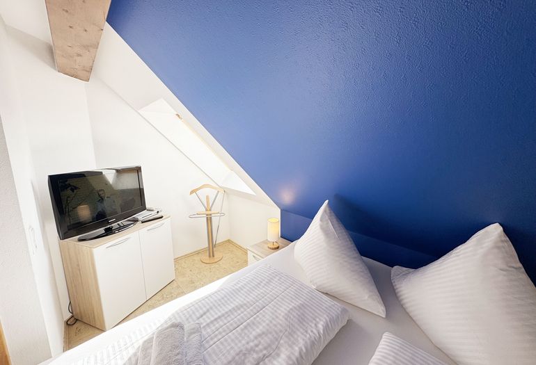 Schlafzimmer mit Doppelbett und Smart-TV Schlafzimmer mit Doppelbett und Smart-TV