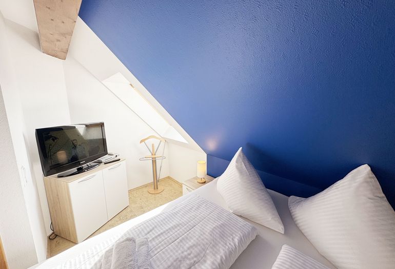 Schlafzimmer mit Doppelbett und Smart-TV